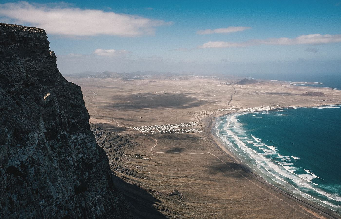 Paisaje de la costa de Lanzarote con montañas volcánicas y el océano